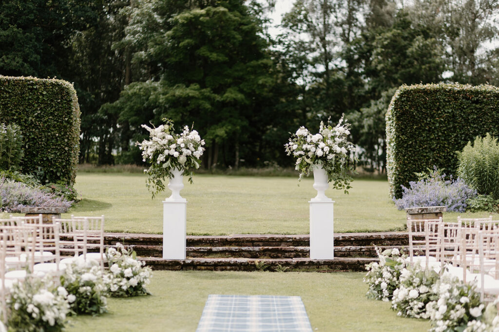 Statement floral installation with lilac and greenery for outdoor ceremony
